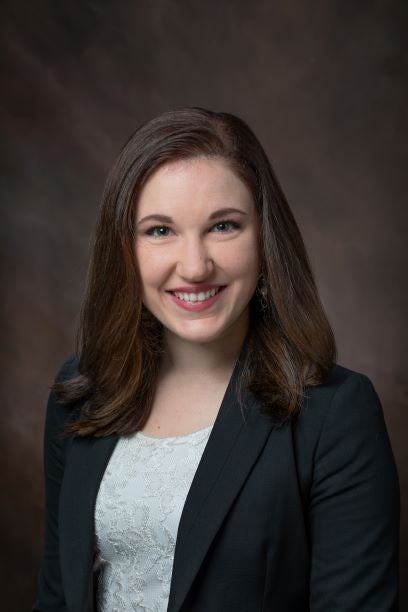 Headshot of Elizabeth Bell against dark background