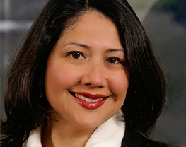 close up headshot of woman smiling in business jacket 