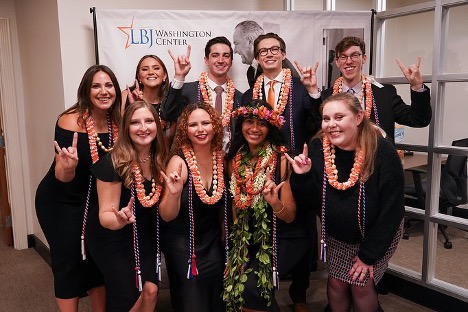 Mauliola Harley Gonzales with classmates putting up a hookem hand sign
