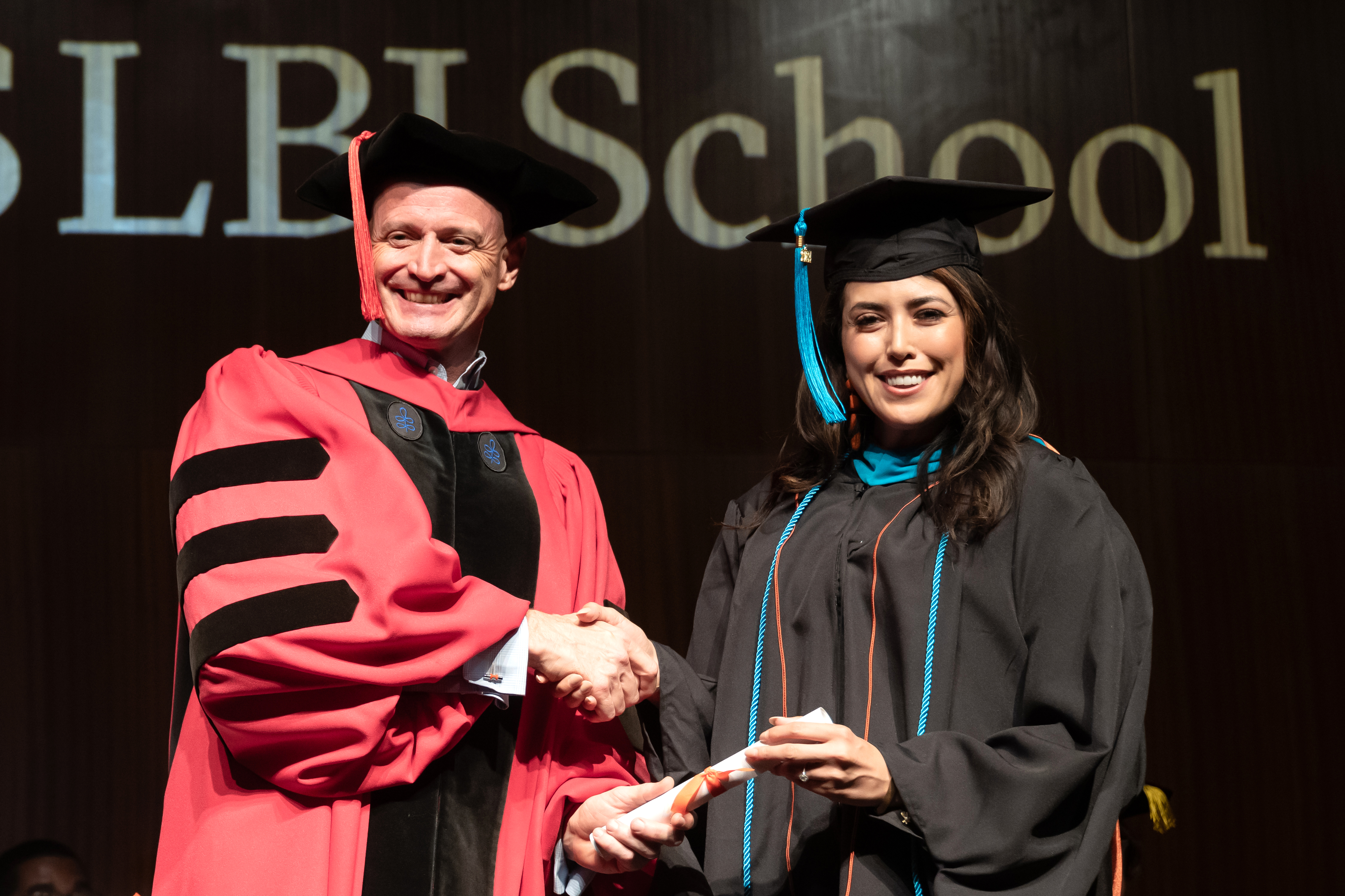Dean JR DeShazo gives a diploma to EMPL graduate Vanessa Fuentes.
