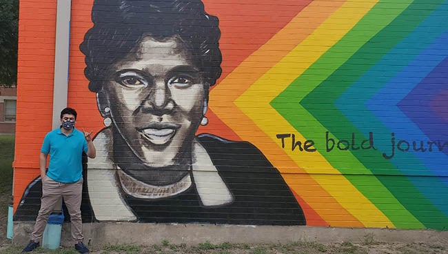 Aaron Escajeda (MPAff / Social Work '21) at the mural at Barbara Jordan Elementary School