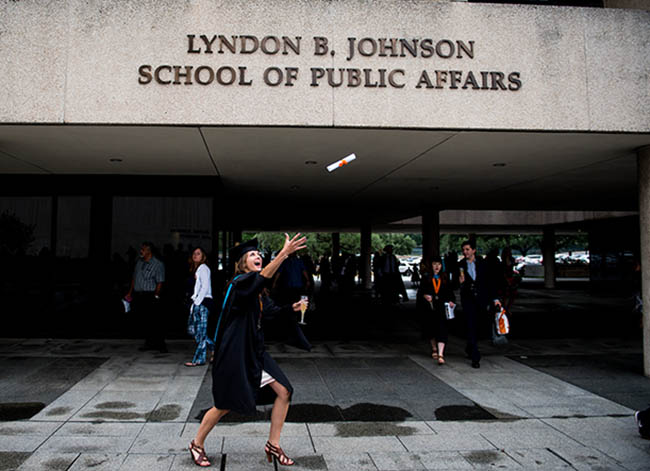 An LBJ graduate tosses her diploma into the air on commencement day