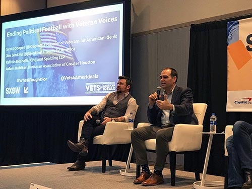 Joe Jenkins and fellow panelist sit on South by Southwest panel with PowerPoint in background