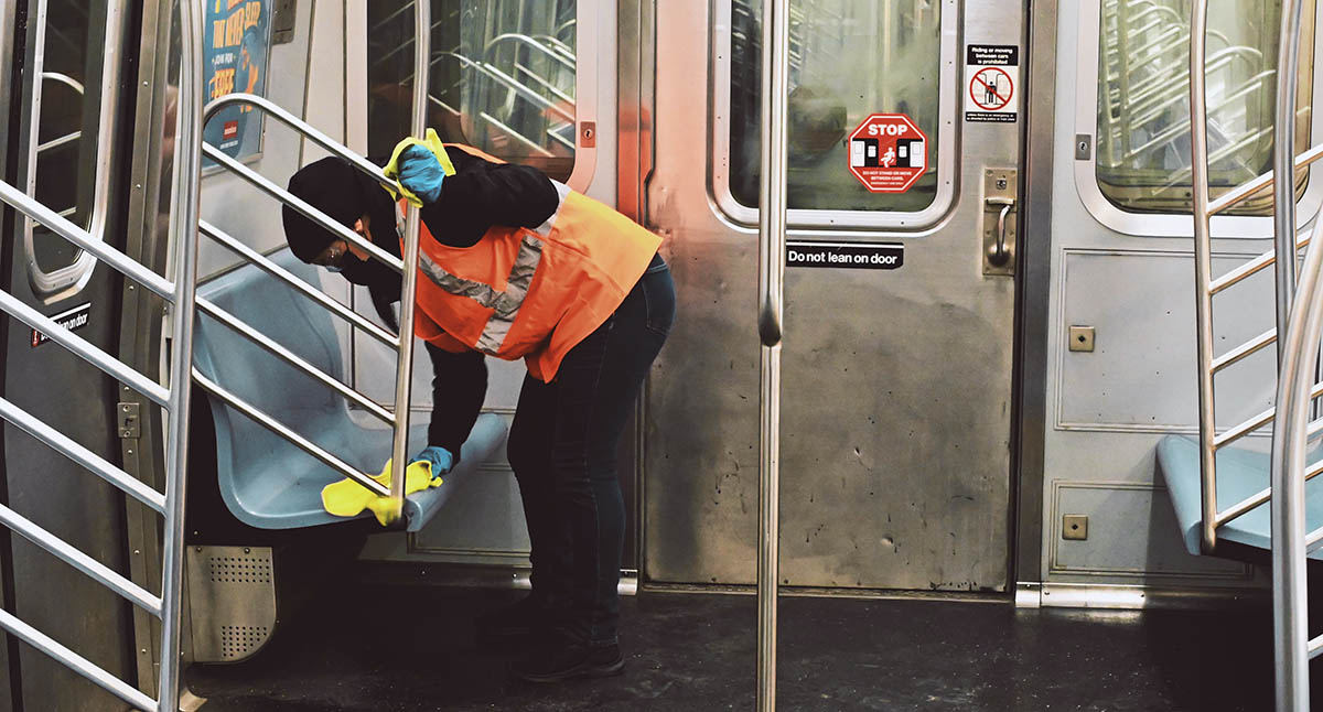 A masked transportation worker cleaning a subway car. Credit: Robinson Greig, Unsplash