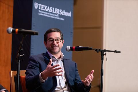 LBJ professor Doug Lewin speaking in front of a mic