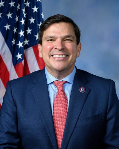 Headshot of US Rep Vincente Gonzales in front of blue background and US flag