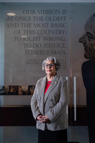 Senfronia Thompson standing in front the the LBJ mural glass