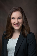 headshot of elizabeth bell against grey background