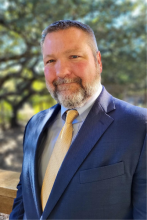 Headshot of Michael Dennis against trees