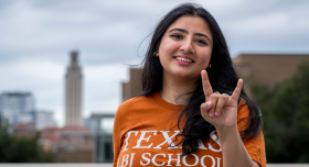 Rania Sohail posing with a hookem hand sign in front of the UT Tower