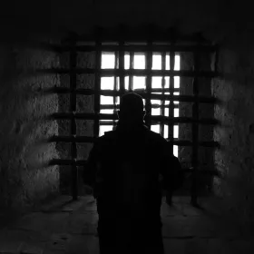 Image of man behind bars