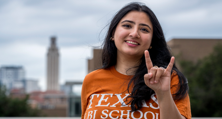 Rania Sohail posing with a hookem hand sign in front of the UT Tower