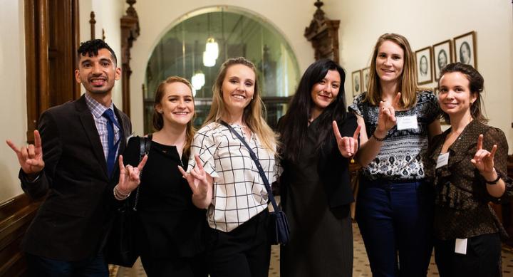 LBJ students intern at the Texas Legislature while holding the hookem hand sign