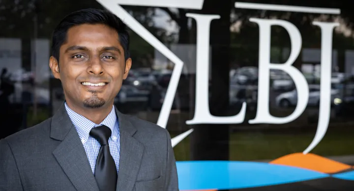 PhD candidate Vivek Shastry posing in front of the LBJ sign.