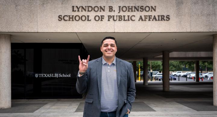 LBJ alumni, Steven Santoyo, in front of LBJ School hook 'em
