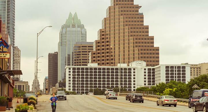 Austin skyline with person riding an electric scooter — credit Avi Werde Austin skyline with person riding an electric scooter — credit Avi Werde
