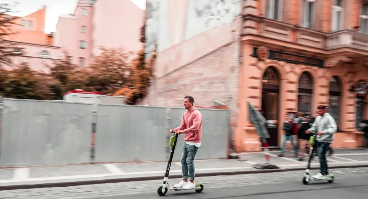 Two men riding scooters down a city street. Credit Marek Rucinski, Unsplash Two men riding scooters down a city street. Credit Marek Rucinski, Unsplash